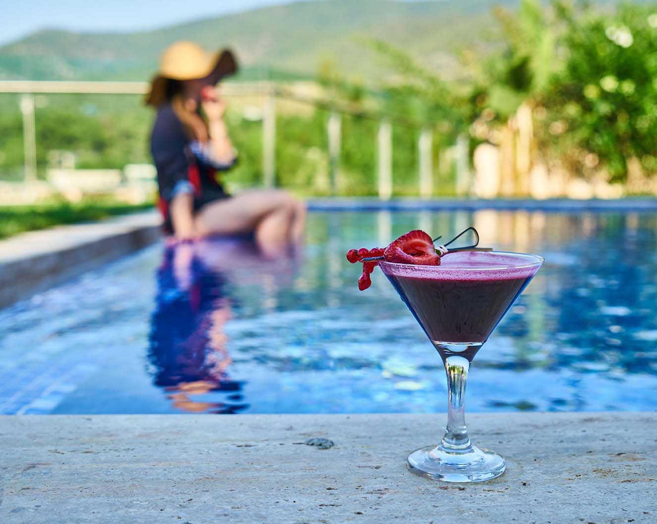 close up of a refreshing fruity drink next to a swimming pool