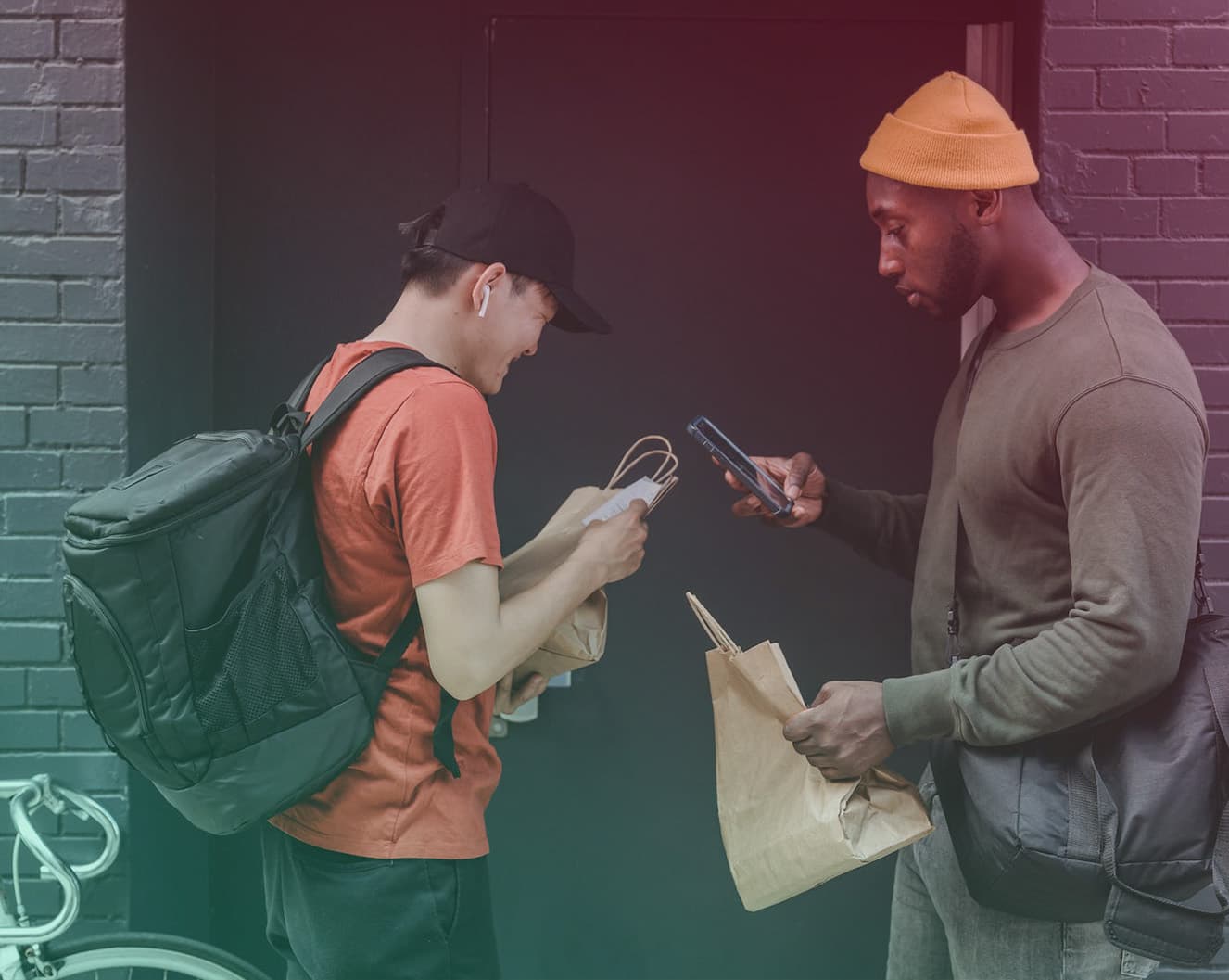 photo of two delivery people looking confused at their phone and an address on a bag